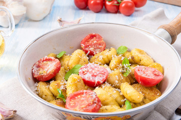 gnocchi baked with green pesto, cherry tomatoes and parmesan
