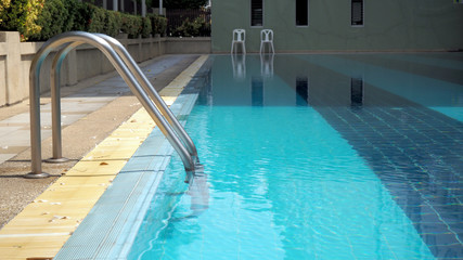 Stairs up the pool. The area around the pool is not clean, full of leaves.
