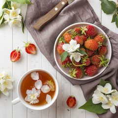 Fresh strawberries and tea with Jasmine flowers on a light background. Summer concept