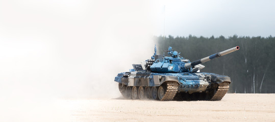 Military armored tank driving in mud at the open field. copyspace