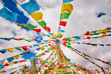 Looking up at Buddhist prayer flags. Tibetans believe the prayers and mantras will be blown by the...