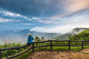 Fototapeta na wymiar The girl in blue jacket touring on Phu-Ruea mountain. Thailand.