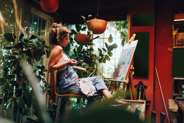 Woman painter painting in her painting studio.