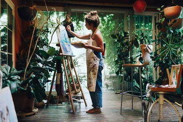 Fotobehang Woman drawing on a camvas in art studio © Manu Reyes