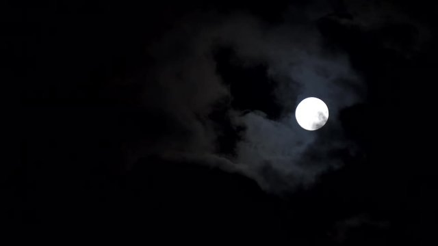 Full moon with clouds passing by
