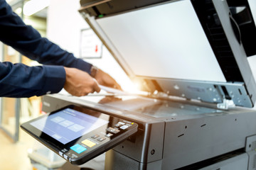 Bussiness man Hand press button on panel of printer, printer scanner laser office copy machine supplies start concept.