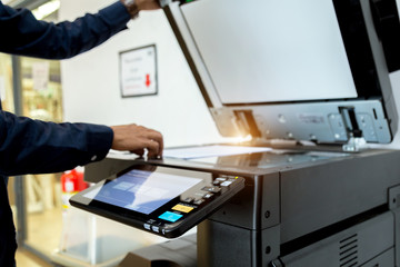 Bussiness man Hand press button on panel of printer, printer scanner laser office copy machine supplies start concept.