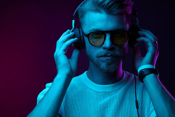 Neon portrait of bearded man in headphones, sunglasses, white t-shirt. Listening to music