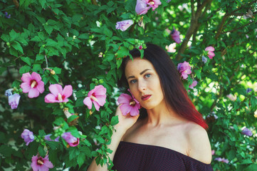 Naklejka premium Beautiful girl in the garden with flowers . Portrait of a young girl in a summer Park