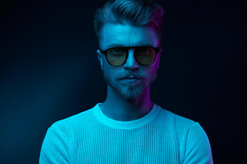 Neon light portrait of serious man model with mustaches and beard in sunglasses and white t-shirt - 216136441