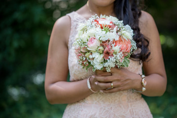 Wedding bouquet - Beautiful flowers in bride's hands in a white dress.