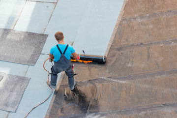 Dachdecker versiegelt ein Flachdach