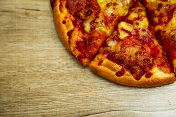 American pizza with pepperoni on a wooden table.