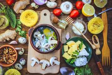 cooking meals mushrooms in batter with egg, herbs and milk. different food ingredients on a wooden background.