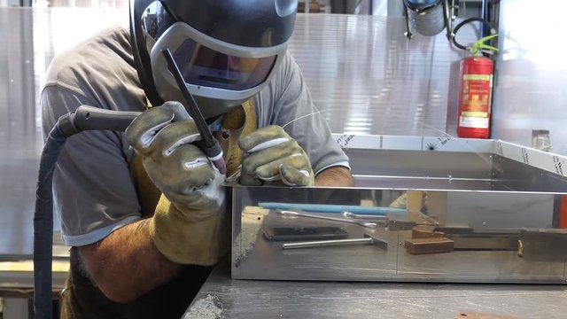 Worker welding steel using TIG welder. Filmed in 4K UHD