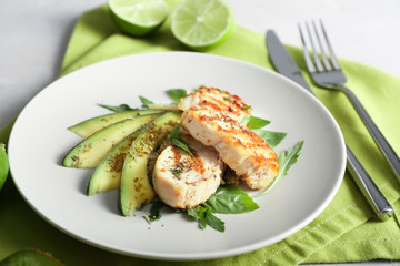 Fototapeta na wymiar Tasty chicken salad with fresh herbs and sliced avocado on plate
