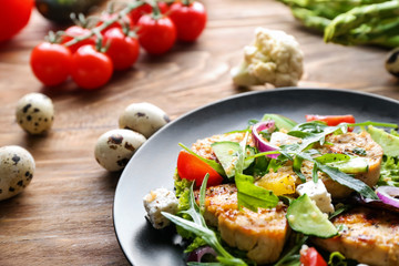 Plate with tasty chicken salad on wooden table, closeup