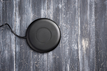 Wireless charger for mobile phone on vintage wooden gray background, top view © jalisko
