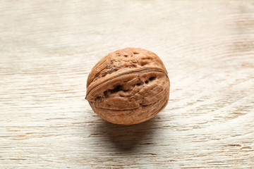 Unpeeled walnut on wooden background