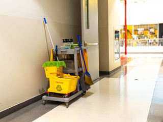 Cleaning tools cart wait for maid or cleaner in the department store. Bucket and set of cleaning equipment in the mall. Concept of service, worker and equipment for cleaner and health