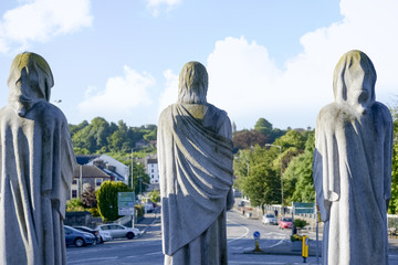 three faceless monk statues outside church