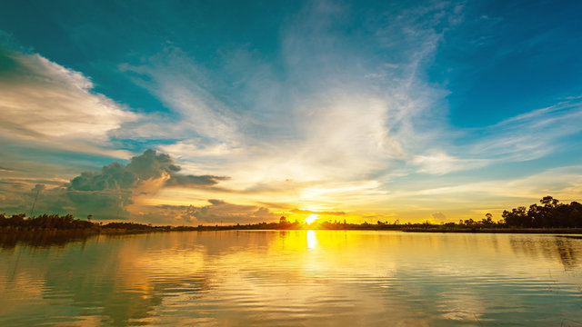Fototapeta Scenery sunset over calm lake landscape panorama, Beautiful sunlight and sunset reflection