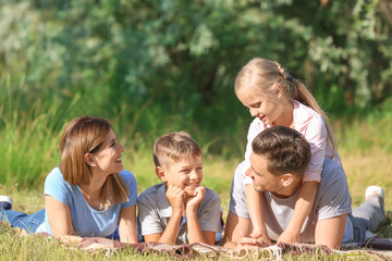 Fototapeta premium Happy family resting in park on summer day