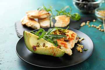 Plate with tasty grilled chicken fillet and ripe avocado on table