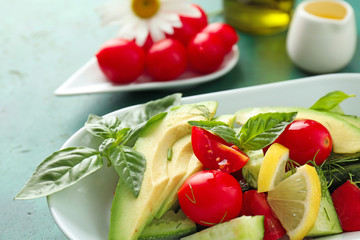 Tasty salad with avocado and tomatoes on plate