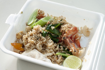 fried rice shrimp in foam box waste condition on white table background.