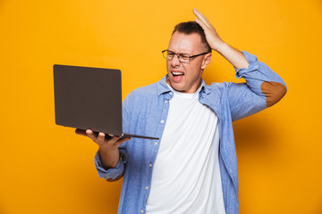 Confused man using laptop computer.
