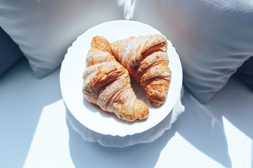 two croissants on a white plate. top view