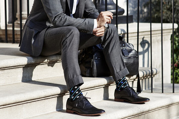 Man in suit sitting on stairs