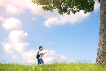 Portrait of school kids running on the grass floor under the tree.