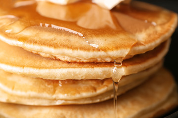 Hot tasty pancakes with honey, closeup