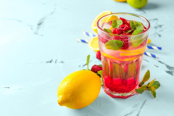 Glass of fresh raspberry mojito and ingredients on table