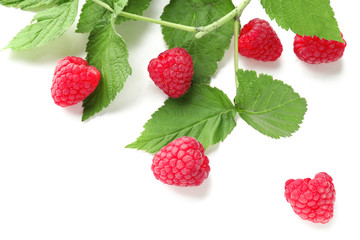 Ripe aromatic raspberries with green leaves on white background