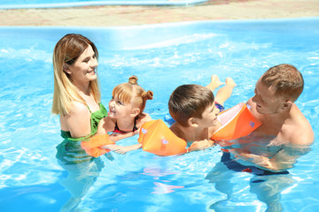 Happy family resting in swimming pool