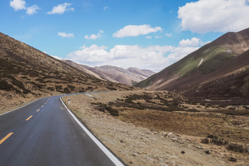 Beautiful Landscape Photography of Mountains / Hills and A Road Under The Clear Blue Sky on The Route Between Shangri-La, Yunnan Province and Yading, Daocheng, Sichuan Province in CHINA.