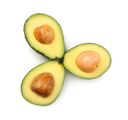 Halves of ripe avocados on white background