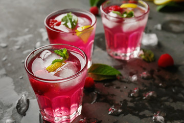 Glasses of fresh raspberry mojito on table
