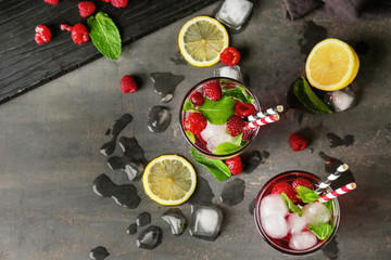 Glasses of fresh raspberry mojito on table