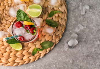 Glass of fresh raspberry mojito on table