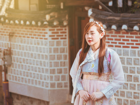 travel and tourist asia concept from beautiful woman in korea traditional cloth (hanbok) relax, take picture in vintage town with soft focus background