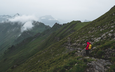 people walking up a steep mountain hiking path covered in fog and rain ridge walk, swiss alps brienzer rothorn