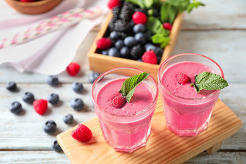 Glasses with tasty raspberry smoothie on wooden table