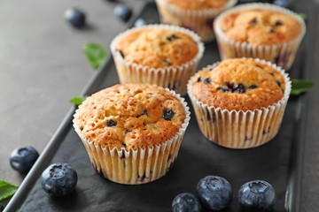 Tasty blueberry muffins on plate, closeup