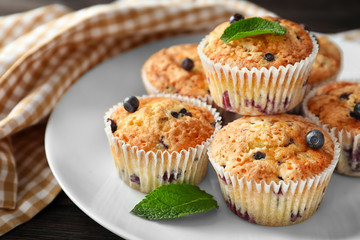 Tasty blueberry muffins on plate, closeup