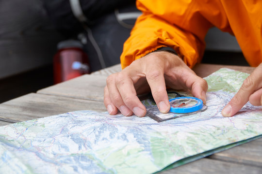 Hiker reading map with compass