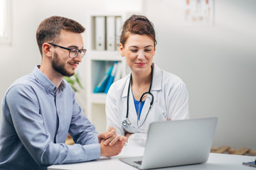 Fototapeta premium Doctor and Intern Looking at Test Results on Laptop
